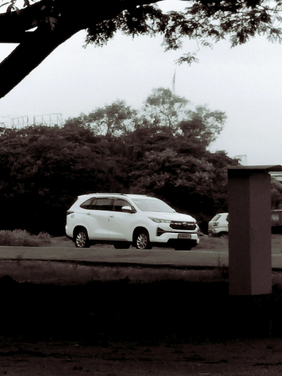 Mobil putih di bawah pohon; foto stok